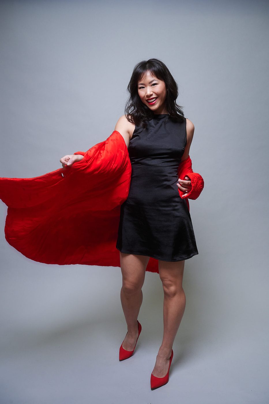 Ashley Chiu, actress and producer, gliding a red coat toward camera